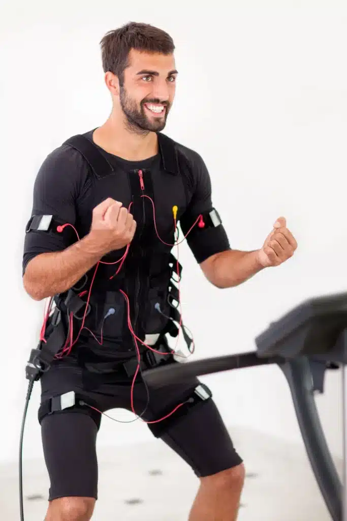 Un homme en pleine séance d'électrostimulation sur tapis roulant dans un centre d'amincissement.